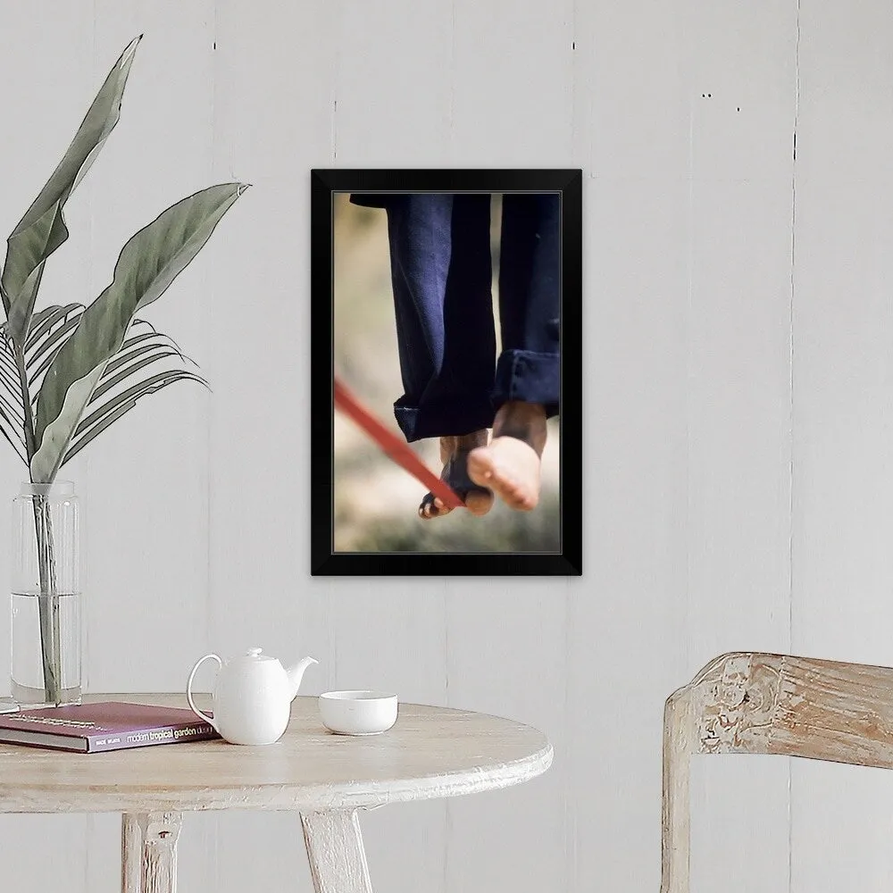"Close up of a man's bare feet balancing on a slackline in the California desert." Black Framed Print