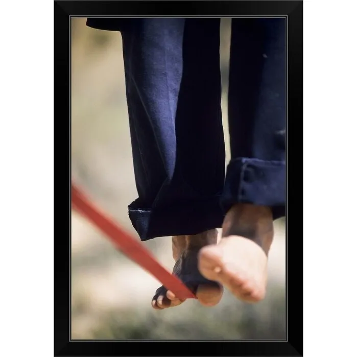 "Close up of a man's bare feet balancing on a slackline in the California desert." Black Framed Print